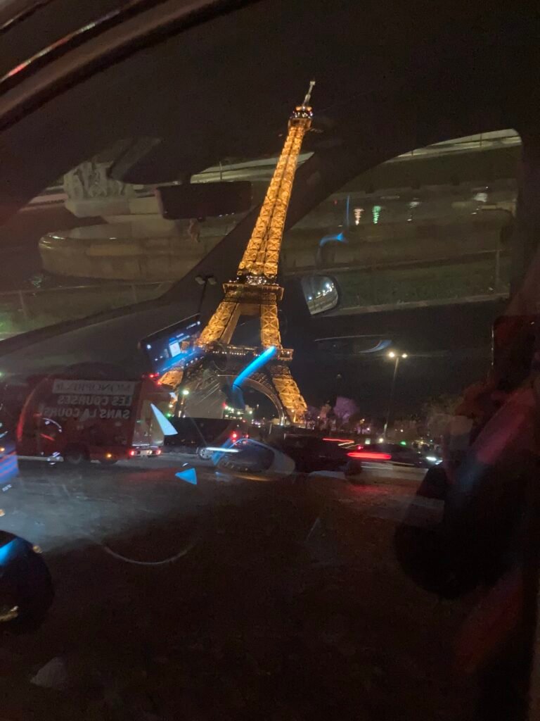 Annulation vtc paris : Tour Eiffel illuminée vue à travers le pare-brise d'un VTC à Paris la nuit