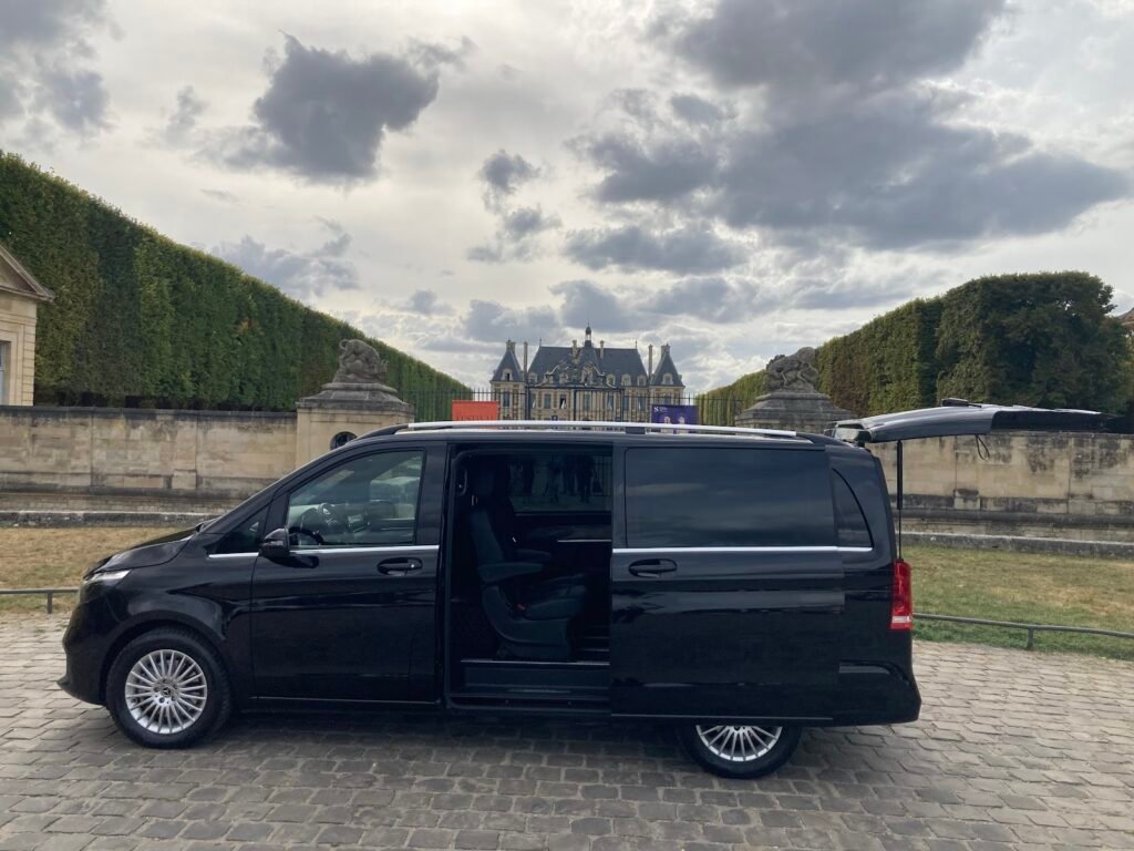 Van Mercedes Classe V de Meers VTC, porte latérale ouverte, garé devant un château d'Île-de-France