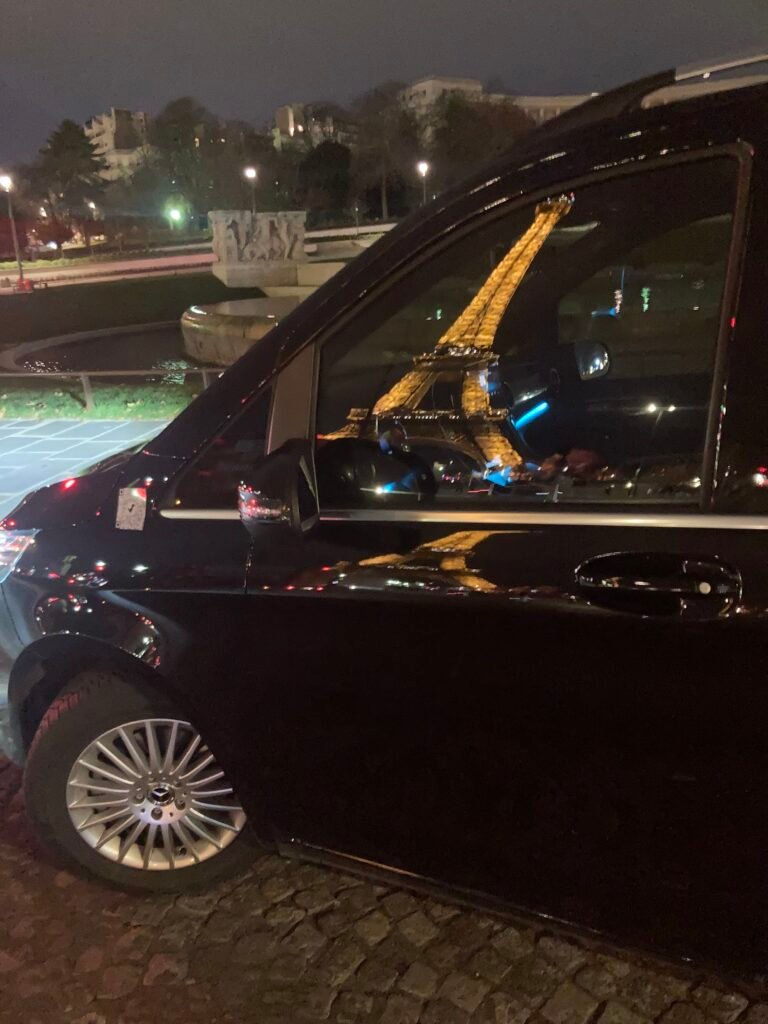 VTC clamart : Reflet de la tour Eiffel illuminée dans la portière d'un van VTC Mercedes la nuit à Paris